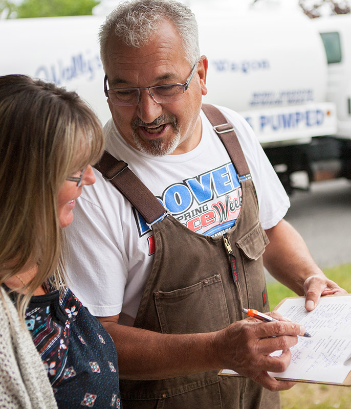 Guy talking to woman and point at a clipboard